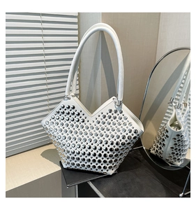 Détail du sac à bandoulière en cuir blanc avec rivets argentés et ouverture en V