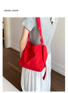 Detailed view of a bright red large canvas tote bag with adjustable strap and coin purse