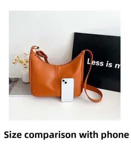 Sac hobo orange en cuir avec comparaison de taille par rapport à un smartphone