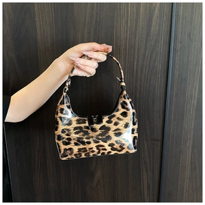 Close-up of leopard print handbag with glossy patent leather finish and black zipper