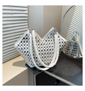 Détail du sac cabas blanc en V avec des rivets argentés et des poignées en cuir