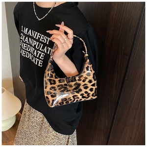 Close-up of a glossy leopard print crescent bag with polished metal dual zippers