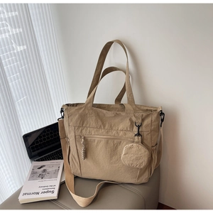 Macro detail of khaki nylon tote bag featuring texture surface and braided zipper puller