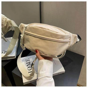 Detail van de crème nylon heuptas met touwritsen en verstelbare zwarte gespsluiting