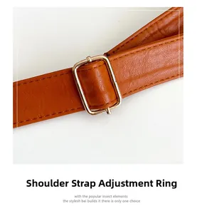 Détail de la boucle dorée réglable sur un sac cabas en cuir marron avec coutures fines