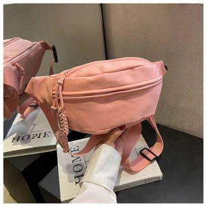 Detail van roze nylon schoudertas met geweven rits en verstelbare schouderband