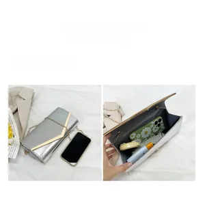 Detail of silver sequin evening clutch bag showing internal space and golden V-bar metal trim