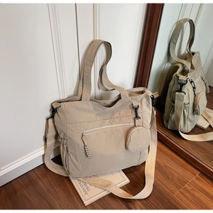 Detail view of large nylon tote bag with small round pouch and adjustable shoulder strap