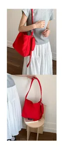 Detailed view of red canvas tote bag with a small matching pouch and wide shoulder strap