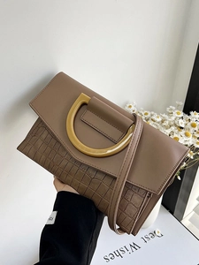 Elegant brown crocodile pattern handbag with a golden D-ring and crossbody strap
