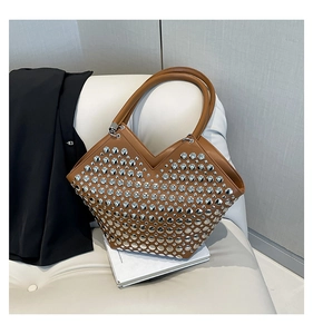 Détail montrant les rivets argentés et l'ouverture en V du sac cabas en cuir marron