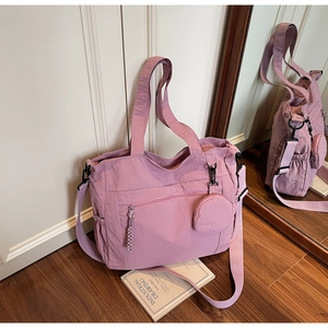 Detail of mauve nylon tote bag featuring adjustable shoulder strap and small round pouch