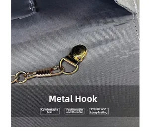Detail of durable golden metal hook and chain on woven fabric interior of evening bag