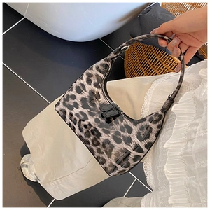 Detailed close-up of glossy leopard print patent leather handbag with silver zipper detail