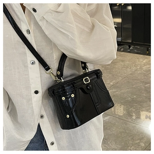 Close-up of black retro box bag with metallic clasp and detachable shoulder strap