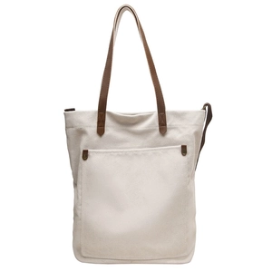 Minimalist cream canvas tote bag with brown straps and a large front pocket