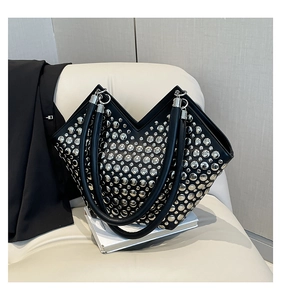 Détail d'un sac cabas punk noir avec rivets argentés et une ouverture unique en forme de V
