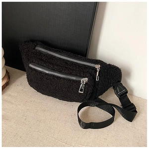 Close-up of black teddy fleece chest bag featuring dual silver metal zippers and strap