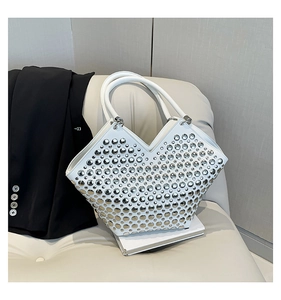 Détail du sac à bandoulière blanc orné de rivets argentés et d'une ouverture en forme de V