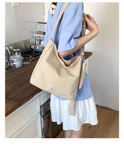 Close-up of a large canvas tote bag with a small matching pouch in a kitchen setting