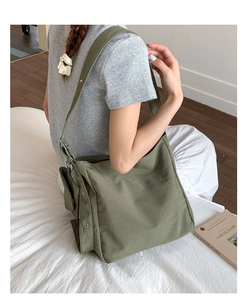 Detailed side view of military green canvas tote bag with adjustable strap and side pocket