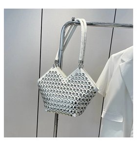 Détail du sac bandoulière en cuir blanc avec rivets argentés et découpe en V en haut
