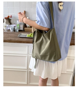 Olive green canvas tote bag shoulder view showing large capacity and soft texture