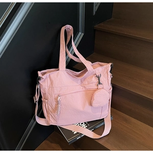 Pink nylon tote bag detail showing shoulder strap, zipper pocket and round coin purse