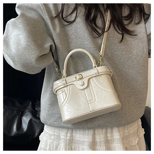 Detail view of cream vintage box bag showing textured PU leather and fine double stitching