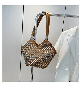 Détail d'un sac à main géométrique marron avec clous argentés suspendu au rack