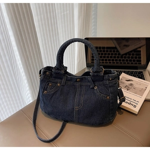 Dettagli della borsa tote in denim blu scuro con tasche, cuciture arancioni e rivetti in metallo