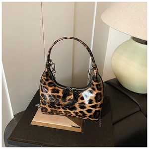 Close-up of leopard print handbag with glossy patent finish and silver chain handle detail