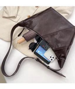 Macro detail of large capacity brown retro shoulder bag showing interior storage space