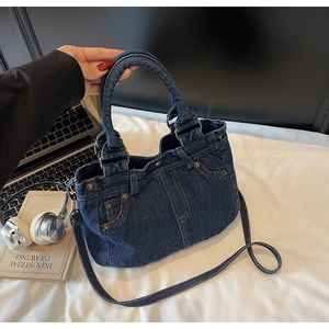 Dettaglio della borsa tote in denim retrò con cuciture classiche e rivetti