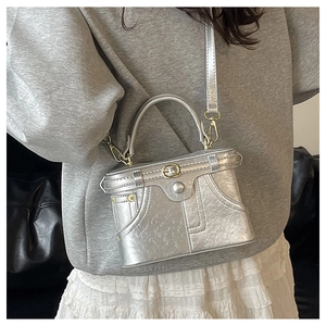 Close-up of silver denim-style box bag with metallic finish and zipper stitching