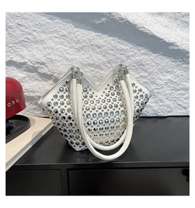 Détail du sac à bandoulière en cuir blanc avec clous argentés et design en forme de V