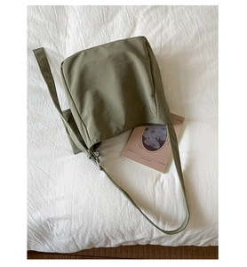 Detail of wide shoulder strap and soft Morandi green canvas fabric on a large tote bag