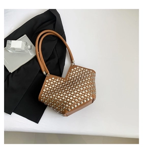 Détail du sac cabas marron avec rivets argentés et ouverture en V au design asymétrique