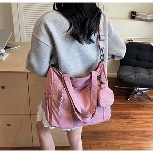Pink nylon tote bag shown from a back view on a model to display large capacity size