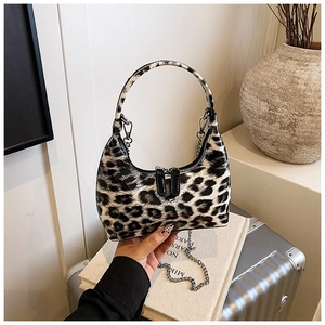 Detailed macro view of the glossy leopard print handbag with a golden chain strap