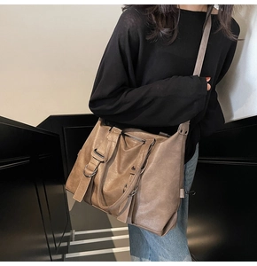 Detail of vintage brown leather tote bag with metal ring buckle and crossbody strap