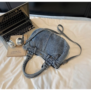 Dettaglio della borsa tote in denim retrò con elementi vintage e tracolle eleganti