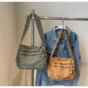 Detail of multi-pocket canvas shoulder bags in green and khaki with adjustable straps