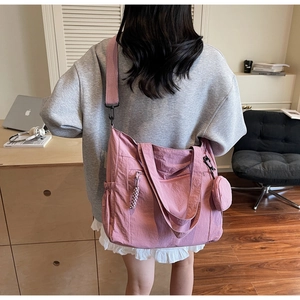 Detail of pink nylon tote bag featuring adjustable strap and matching small round coin purse
