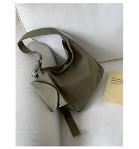 Detail view of olive green nylon hobo bag with metal buckle and small attached pouch