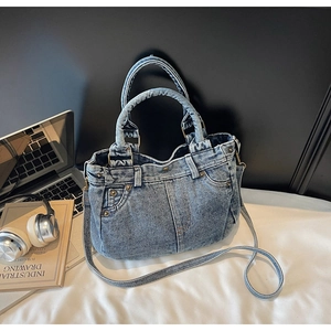 Dettaglio della borsa tote in denim lavato vintage con rivetti e tracolla regolabile
