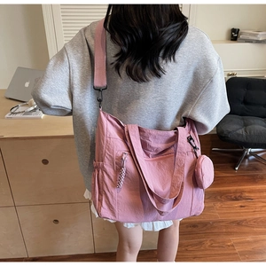 Pink nylon tote bag detail showing detachable round coin purse and adjustable strap