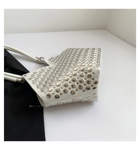 Gros plan détaillé du sac à bandoulière en cuir blanc avec rivets métalliques argentés
