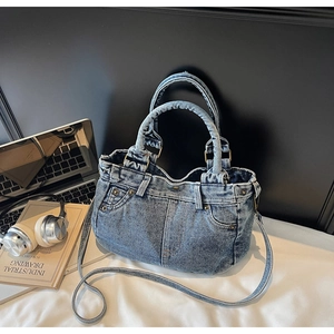 Dettaglio della borsa tote in denim lavato blu con design a tasca e rivetti metallici