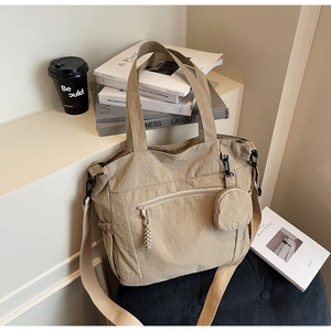 Detailed view of beige nylon tote bag with adjustable shoulder strap and matching coin purse